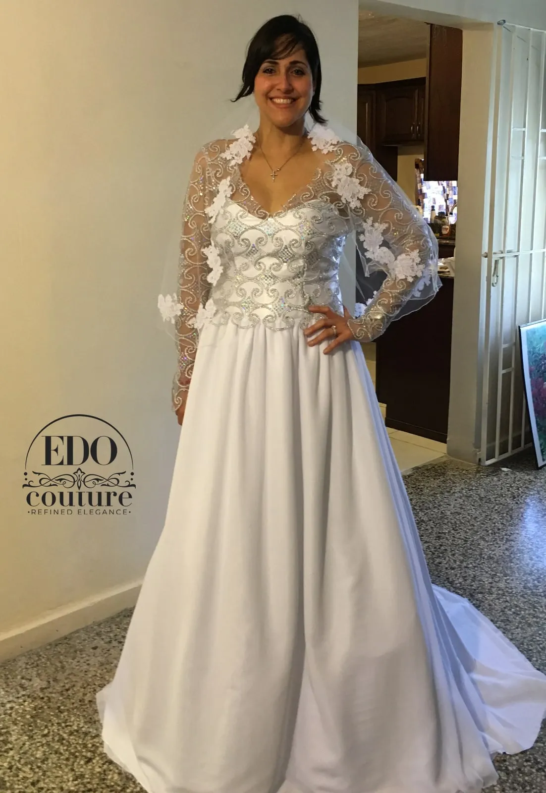Bride in a long-sleeve gown with a silver beaded illusion bodice, lace appliqués and a flowing skirt